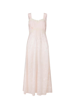 a-pale-blush-pink-sleeveless-maxi-dress-with-a-textured-slightly-sheer-fabric-and-delicate-lace-trim-at-the-neckline-and-upper-bodice-shown-against-a-plain-white-background